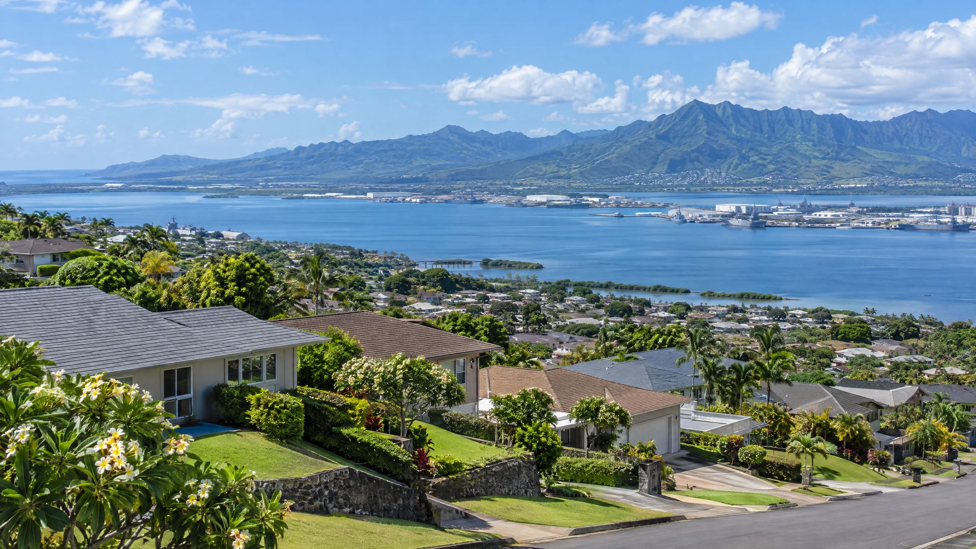 Hillside homes in Pearl City with terraced streets descending toward a broad calm harbor.