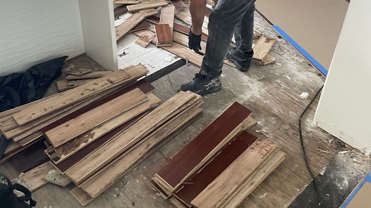 A Rescue One technician removing water-damaged wood flooring that can't be saved.